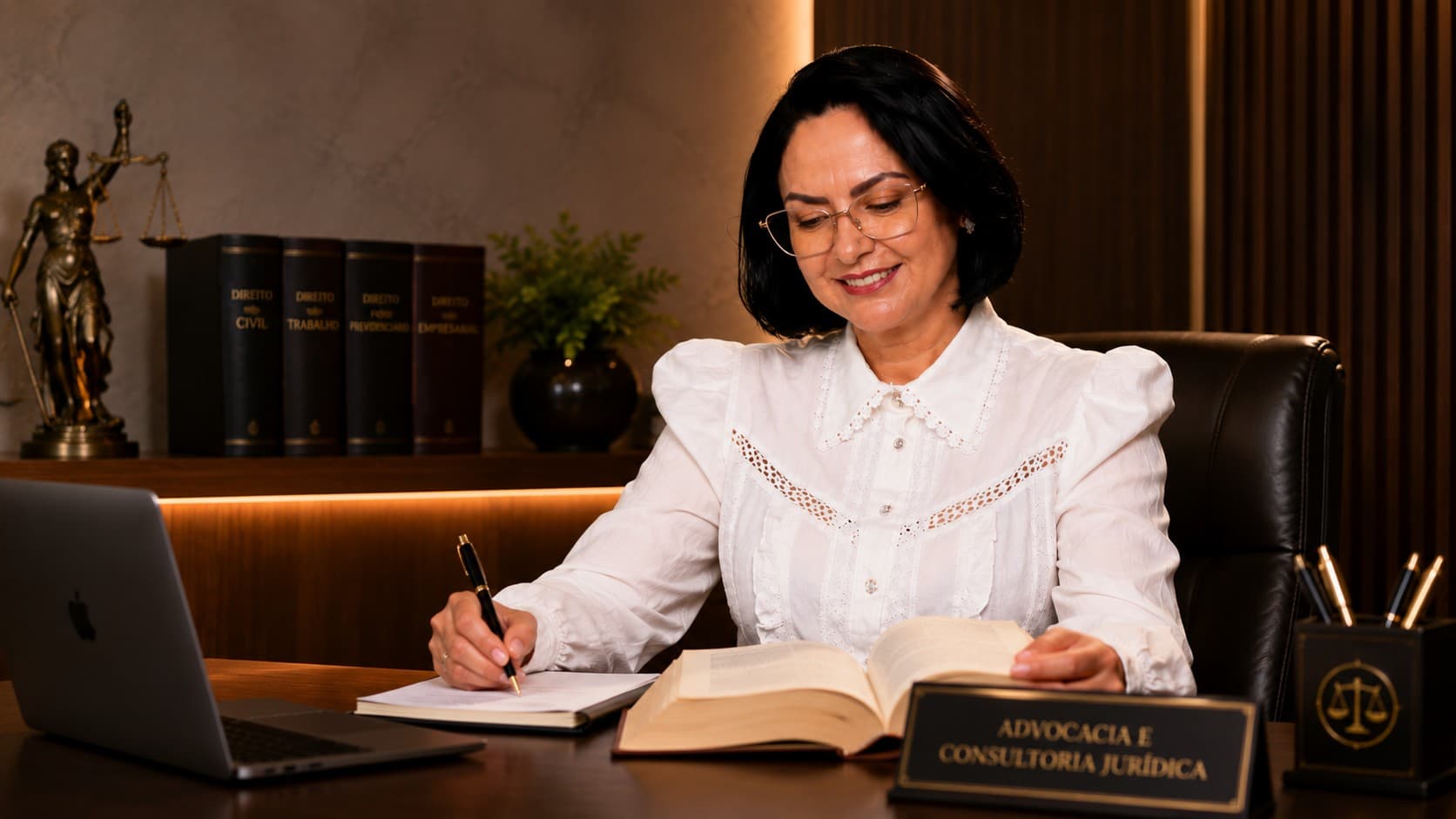 Dra. Sheila Araújo escrevendo em seu escritório